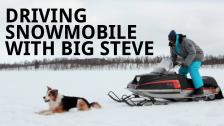 Driving Snowmobile and Lifting Dog